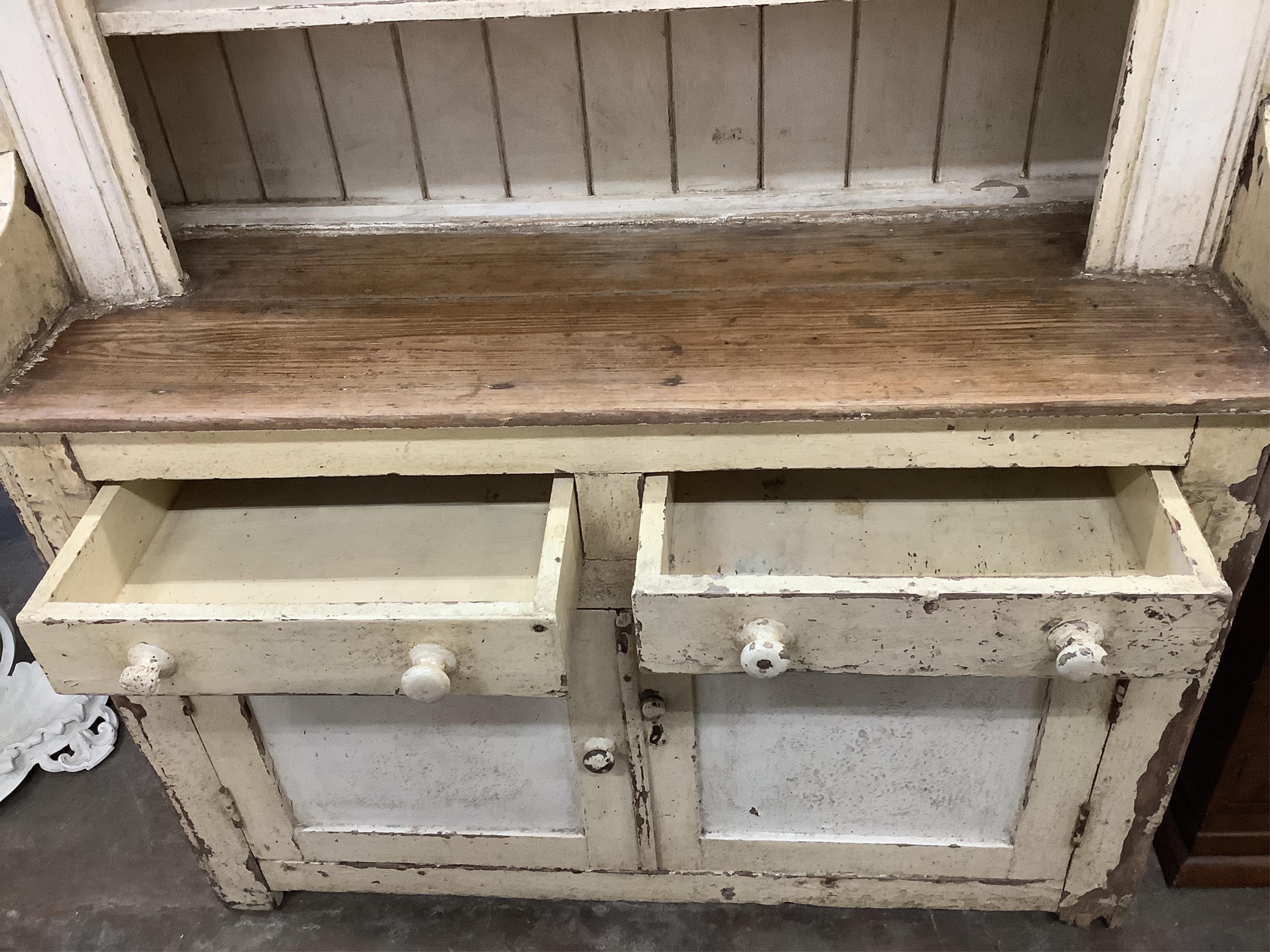 An early 19th century Irish painted pine dresser with boarded rack, width 126cm, depth 49cm, height 210cm. Condition - fair